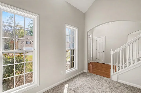 a view of an empty room with wooden floor and windows