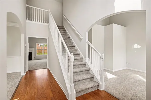 a view of staircase with wooden floor and white walls