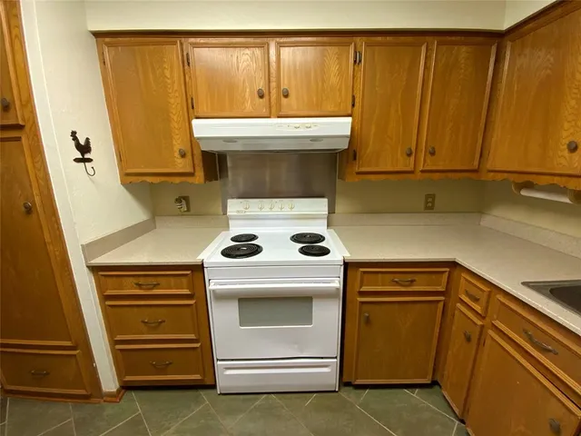 a kitchen with a sink a stove and cabinets