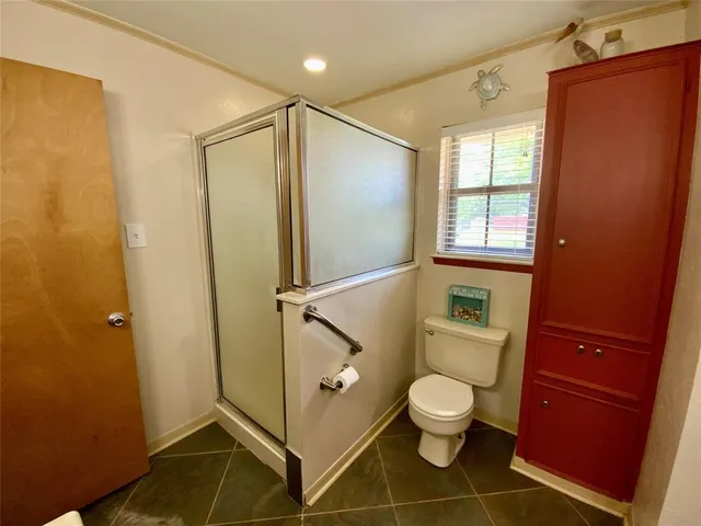 a bathroom with a granite countertop toilet a sink and a shower