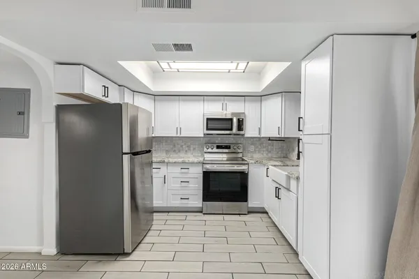 a kitchen with stainless steel appliances granite countertop a refrigerator and a stove top oven