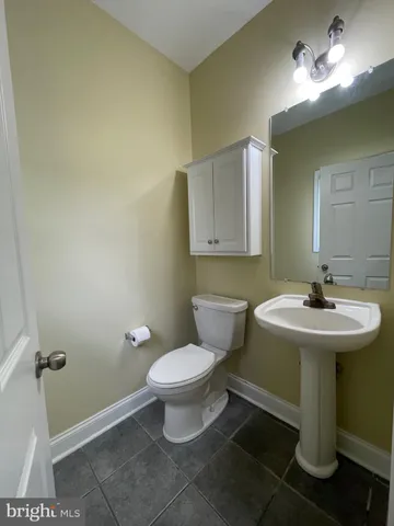 a bathroom with a sink toilet and a mirror