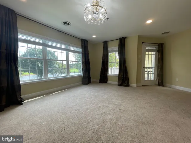 a view of an empty room with a fireplace and a large window