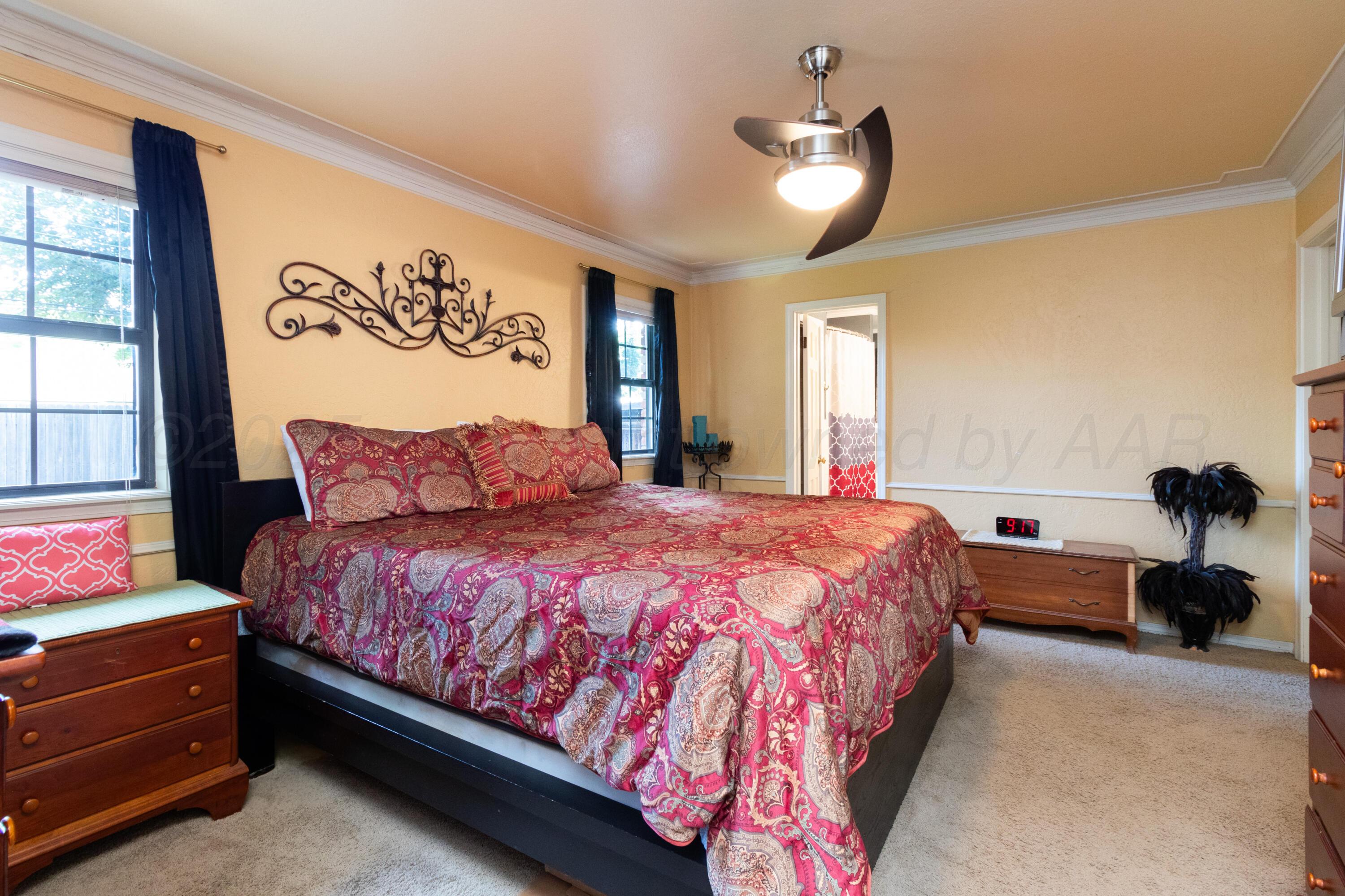 7104 Dreyfuss Road Amarillo, TX 79106 - Photo 18 of 43 a spacious bedroom with a bed and a chandelier