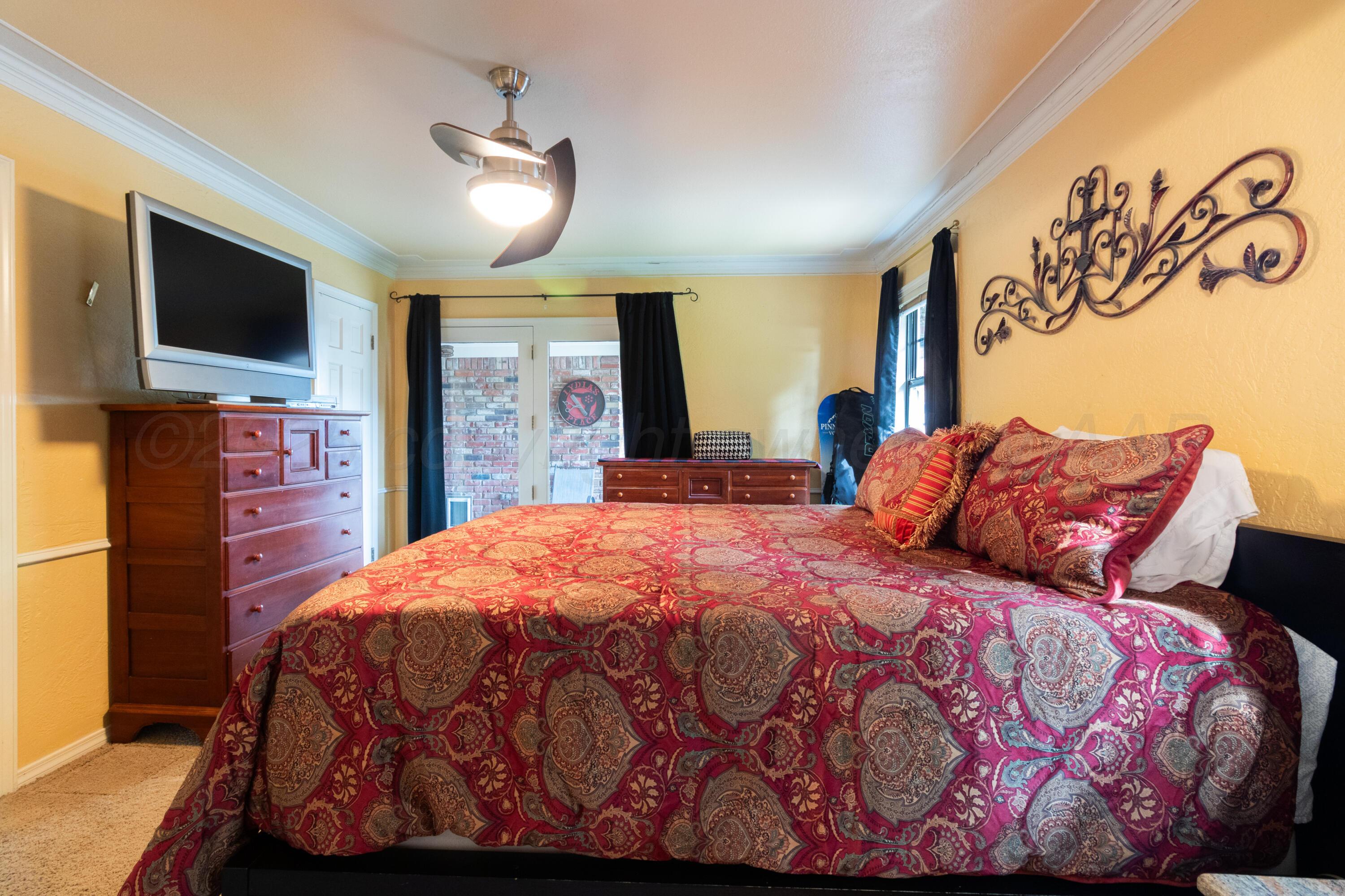 7104 Dreyfuss Road Amarillo, TX 79106 - Photo 19 of 43 a bedroom with a large bed and a flat tv screen on dresser