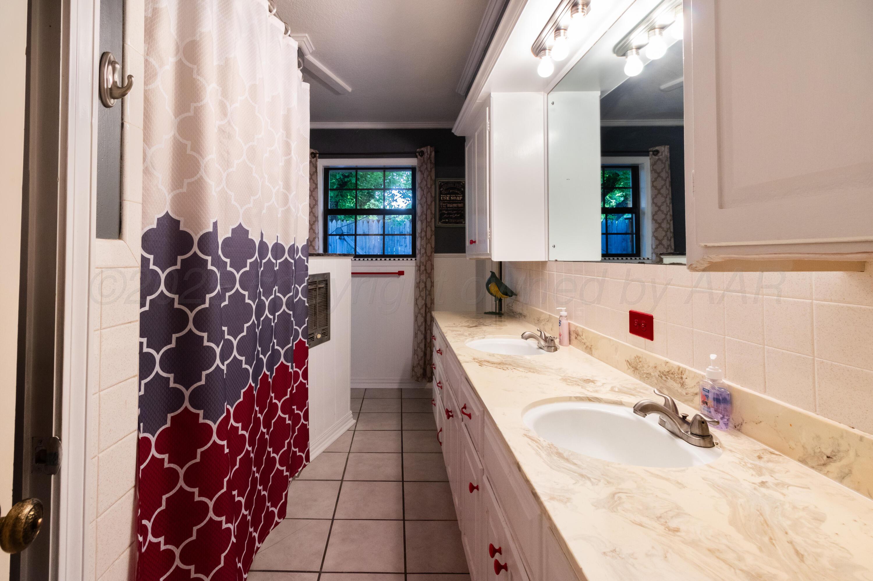 7104 Dreyfuss Road Amarillo, TX 79106 - Photo 21 of 43 a bathroom with a granite countertop sink a mirror and shower