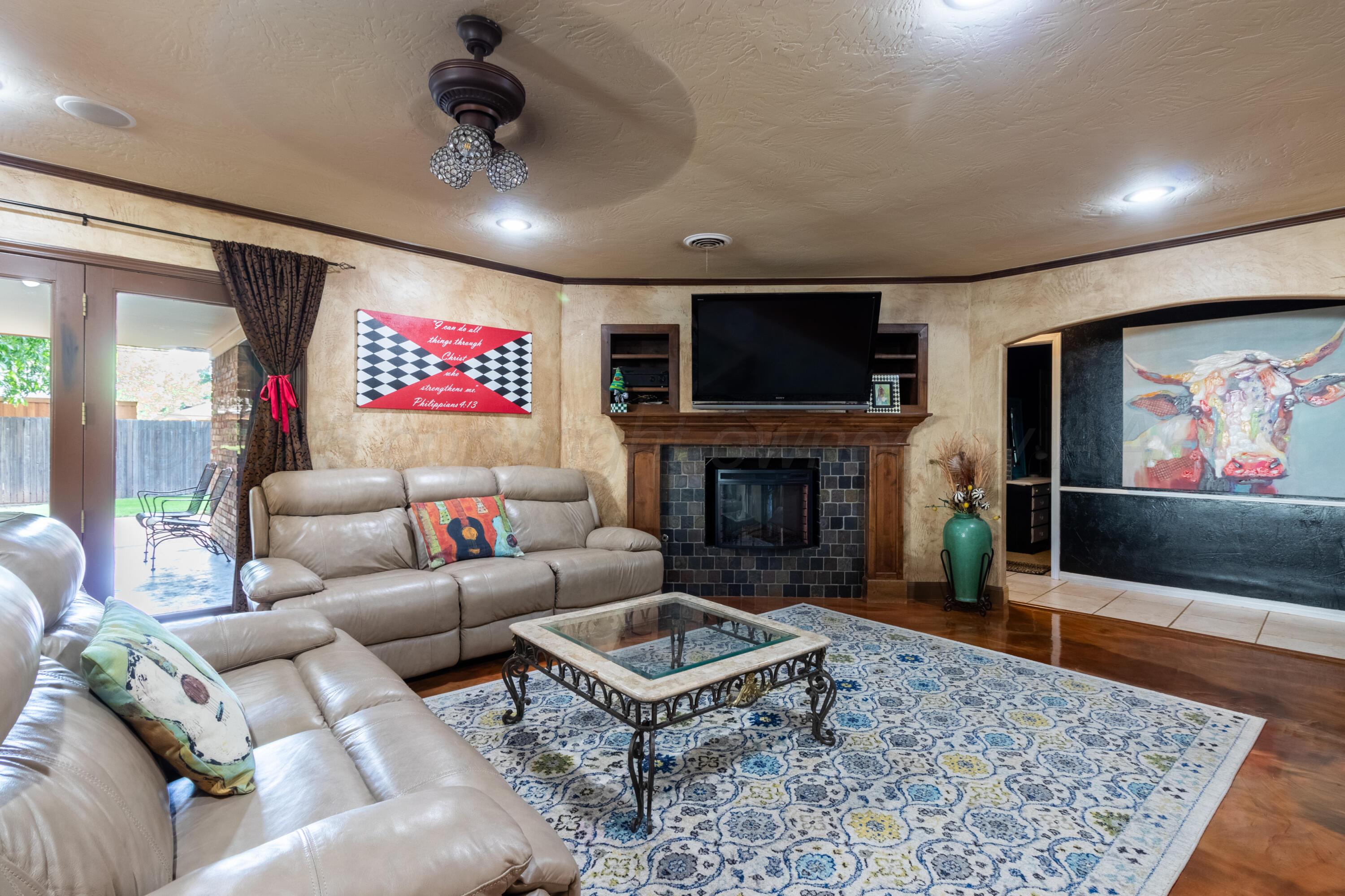 7104 Dreyfuss Road Amarillo, TX 79106 - Photo 6 of 43 a living room with furniture a flat screen tv and a fireplace