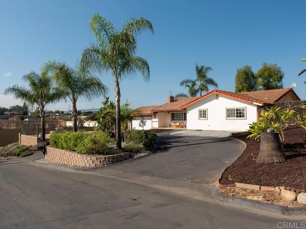 a front view of a house with garden and parking