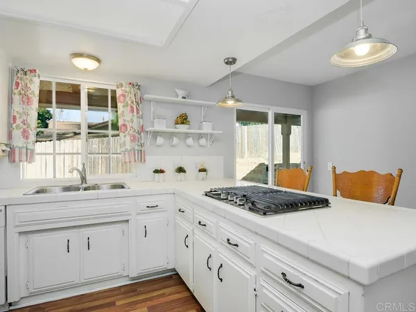 a kitchen with a stove a sink and a window