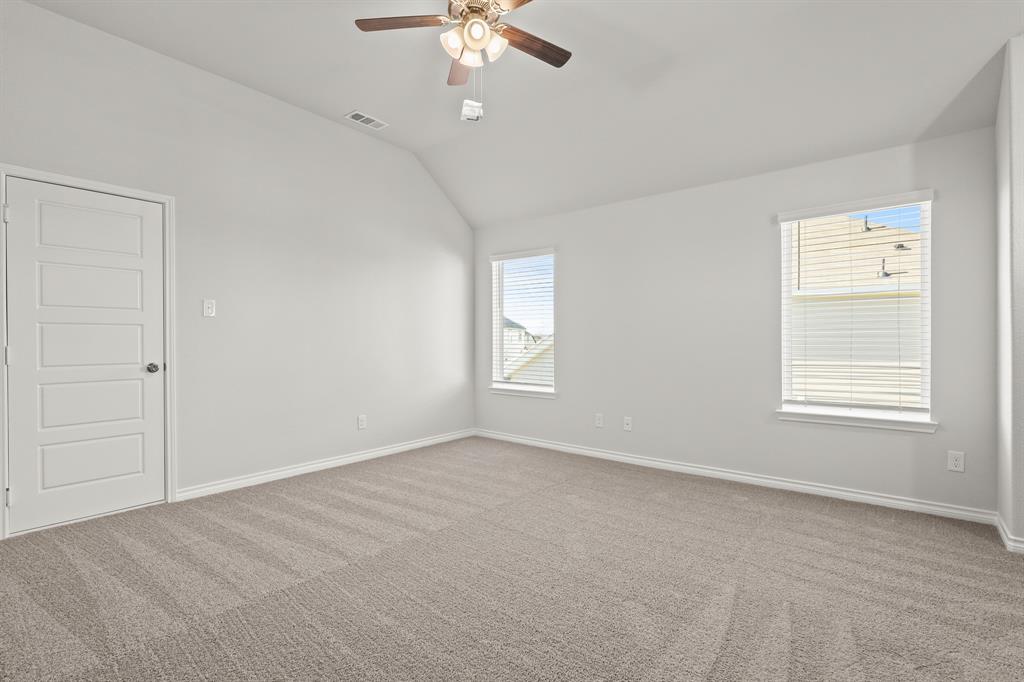 5025 Wellborn Road Crowley, TX 76036 - Photo 12 of 38 an empty room with a chandelier fan and windows