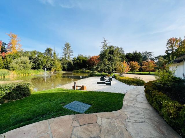 a view of a swimming pool with lawn chairs and a big yard
