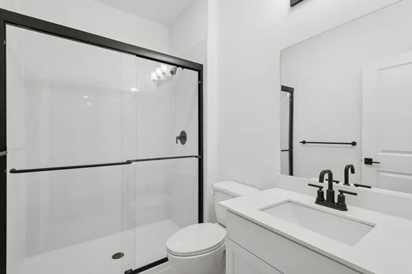 a bathroom with a sink a toilet and a large mirror
