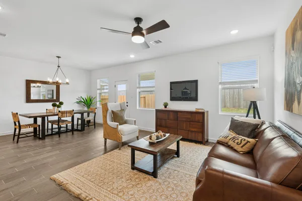 a living room with furniture kitchen view and a potted plant