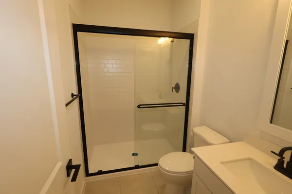 a bathroom with a granite countertop sink toilet and shower