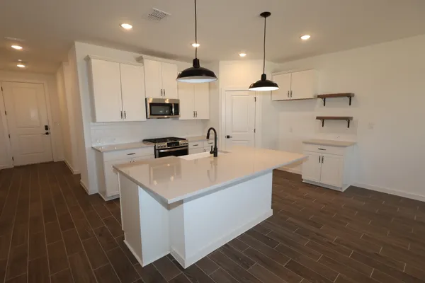 a kitchen with kitchen island a sink stainless steel appliances and white cabinets