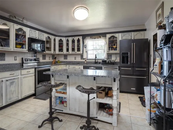 a kitchen with granite countertop a refrigerator and stove