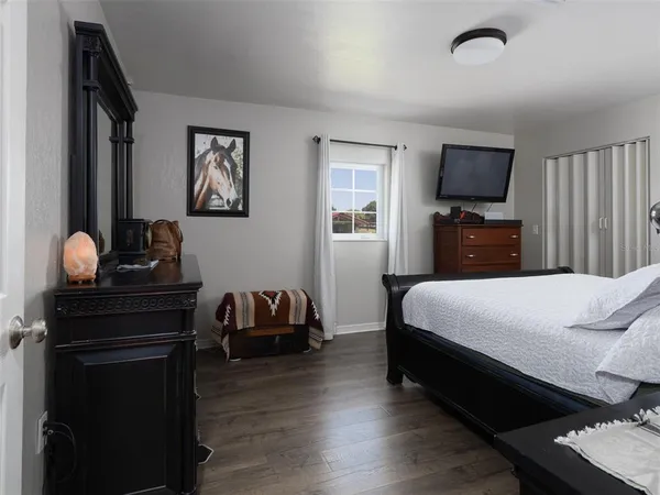 a bedroom with a bed and wooden floor