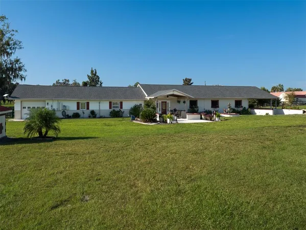 a view of a house with swimming pool and furniture