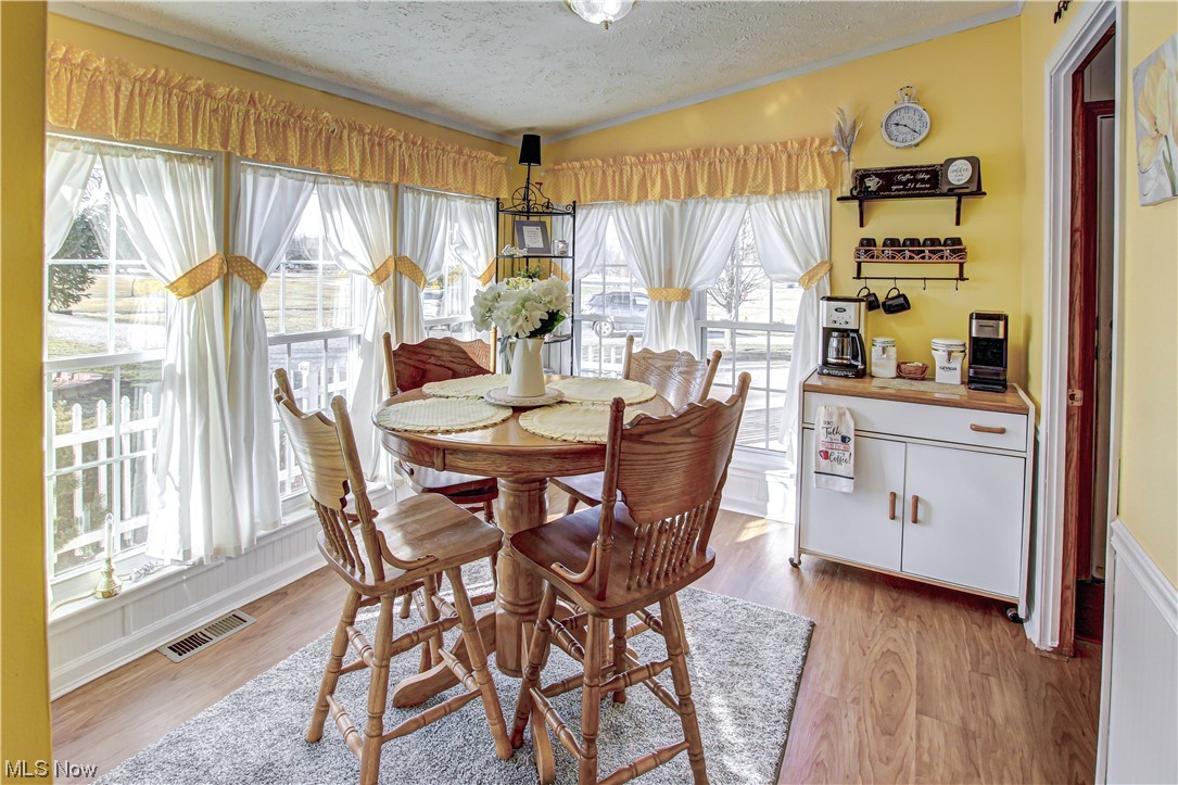 9459 Stone Road Litchfield, OH 44253 - Photo 9 of 50 Dining room featuring light hardwood / wood-style floors and a textured ceiling