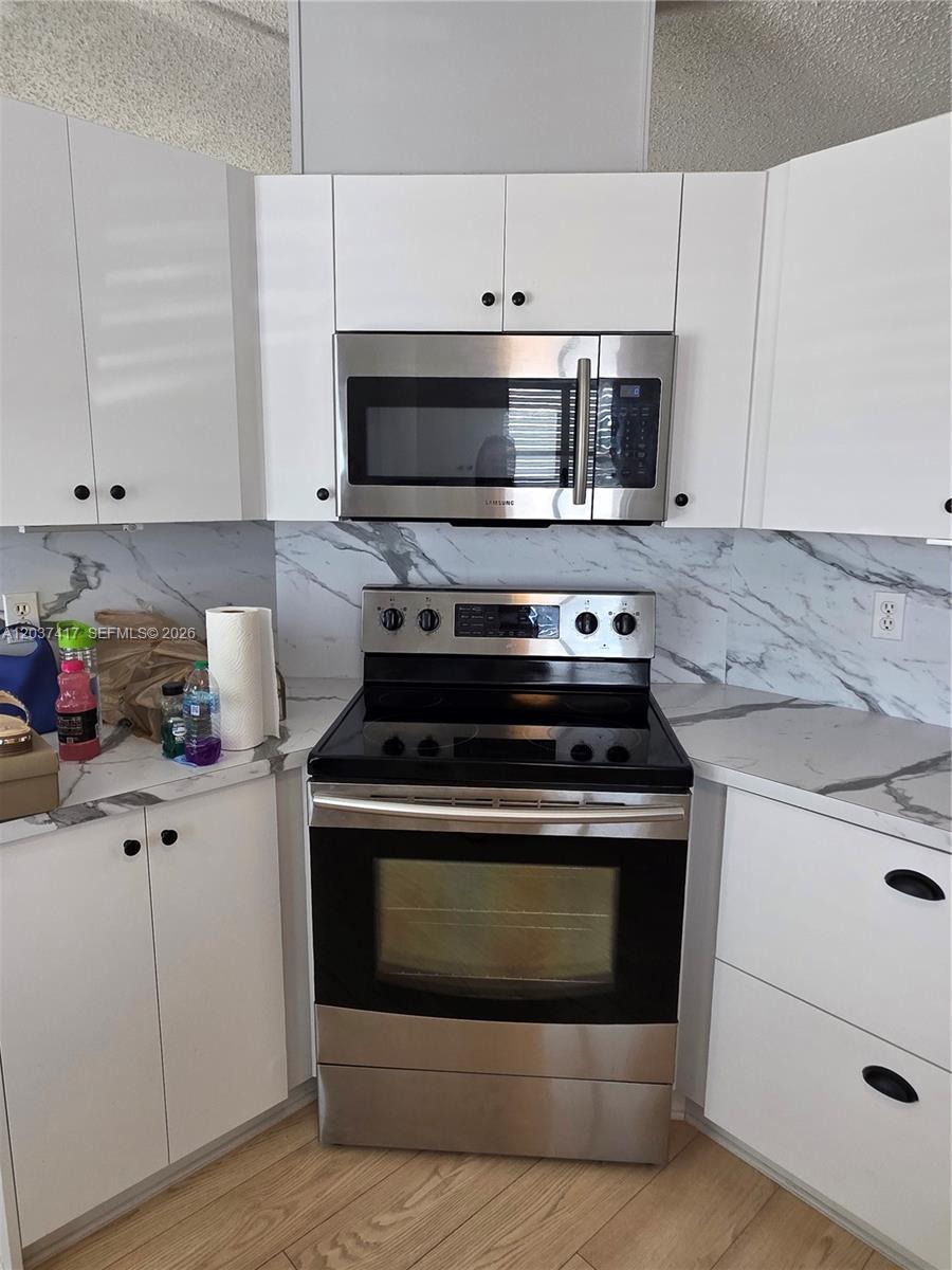 17350 Southwest 232nd Street, Unit 47 Miami, FL 33170 - Photo 7 of 9 a kitchen with a stove and a microwave