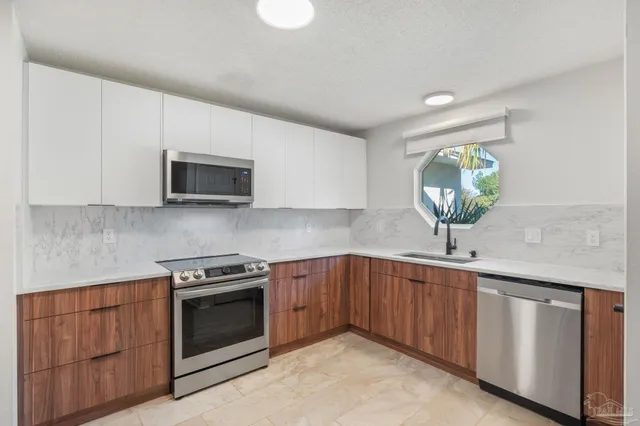 a room with kitchen island a counter top space stainless steel appliances and cabinets