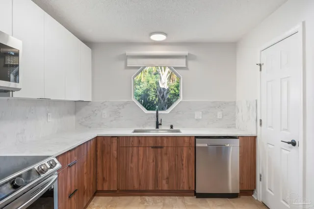 a kitchen with stainless steel appliances a stove a microwave and a refrigerator