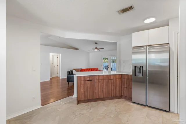 a spacious bathroom with a granite countertop double vanity sink a mirror and a bathtub
