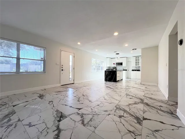 a view of a hallway with wooden floor and a bathroom