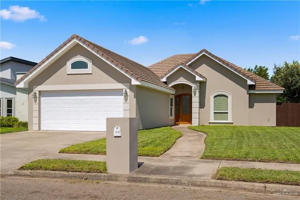 a front view of a house with a yard and garage