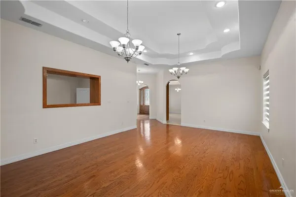 a view of an empty room with a chandelier fan