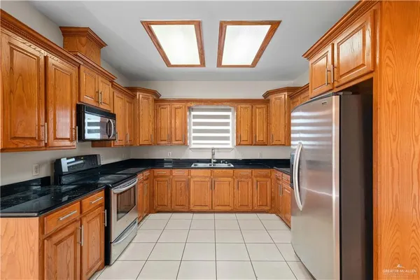 a kitchen with granite countertop stainless steel appliances a sink and cabinets