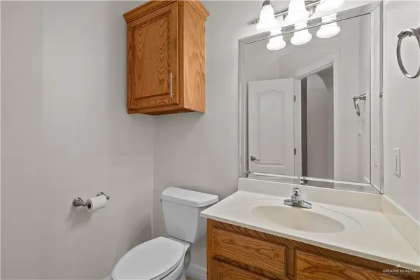 a bathroom with a sink vanity granite toilet and a mirror