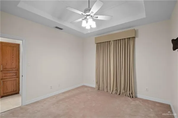 an empty room with windows and ceiling fan