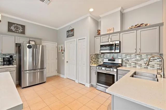 a kitchen with stainless steel appliances a refrigerator sink and microwave