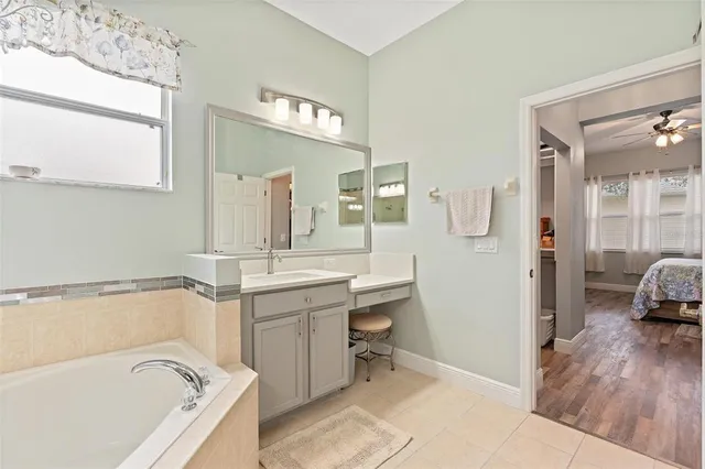 a bathroom with a tub sink and mirror