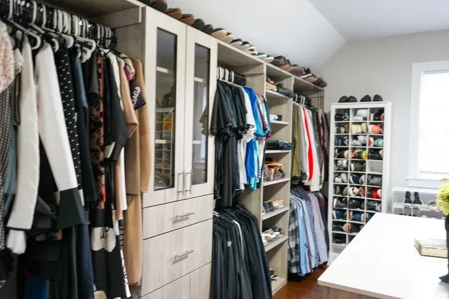 a view of walk in closet with clothes and shoes