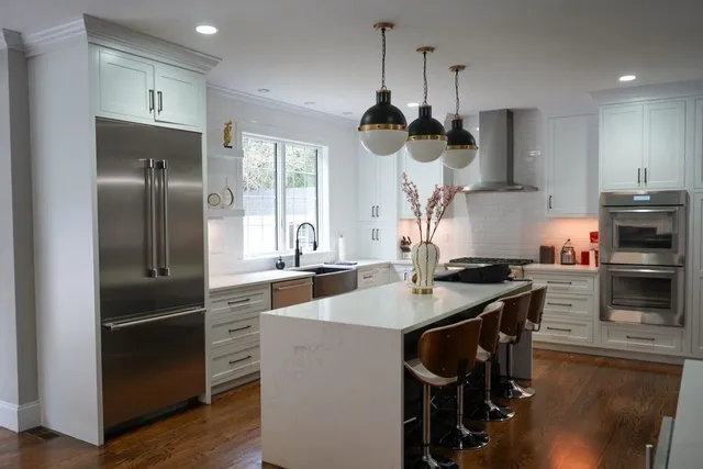 a kitchen with stainless steel appliances granite countertop a sink a stove and a refrigerator