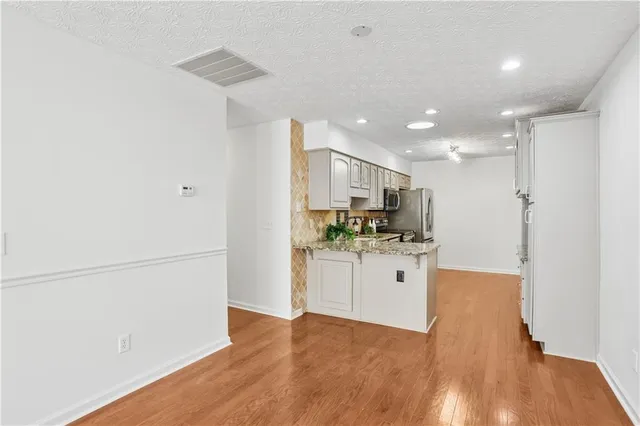a kitchen with white cabinets and refrigerator