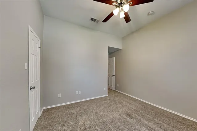 an empty room with chandelier fan