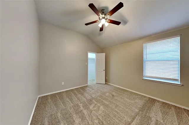an empty room with a window and a ceiling fan