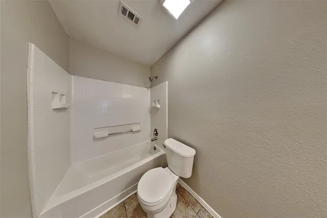 a white toilet sitting next to a bath tub and a shower
