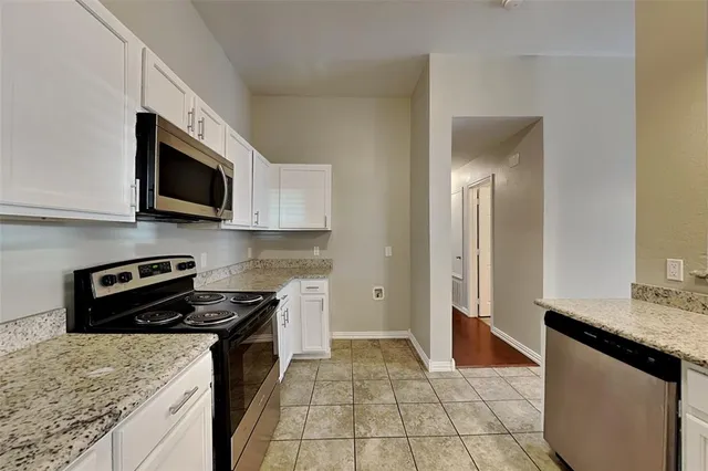 a kitchen with stainless steel appliances granite countertop a sink stove and microwave
