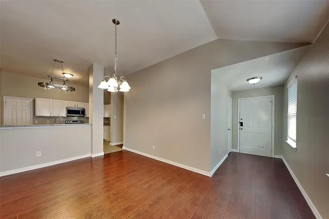 a view of a kitchen with a refrigerator a ceiling fan and wooden floor