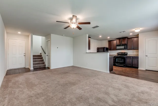 a view of a kitchen with a sink and a ceiling fan