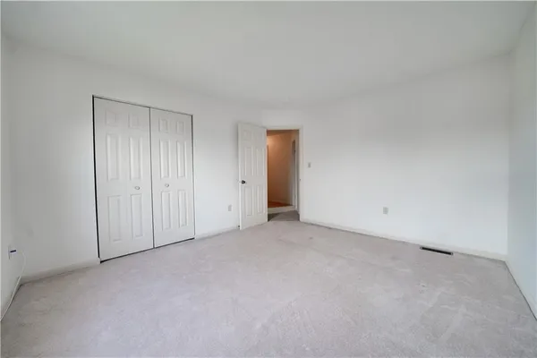 a spacious bedroom with a bed and a chandelier
