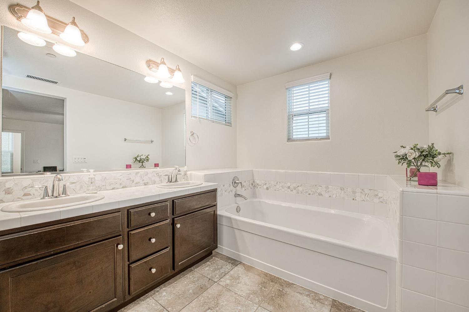 123 Capstone Way South Madera, CA 93636 - Photo 15 of 32 a bathroom with a tub sink and mirror