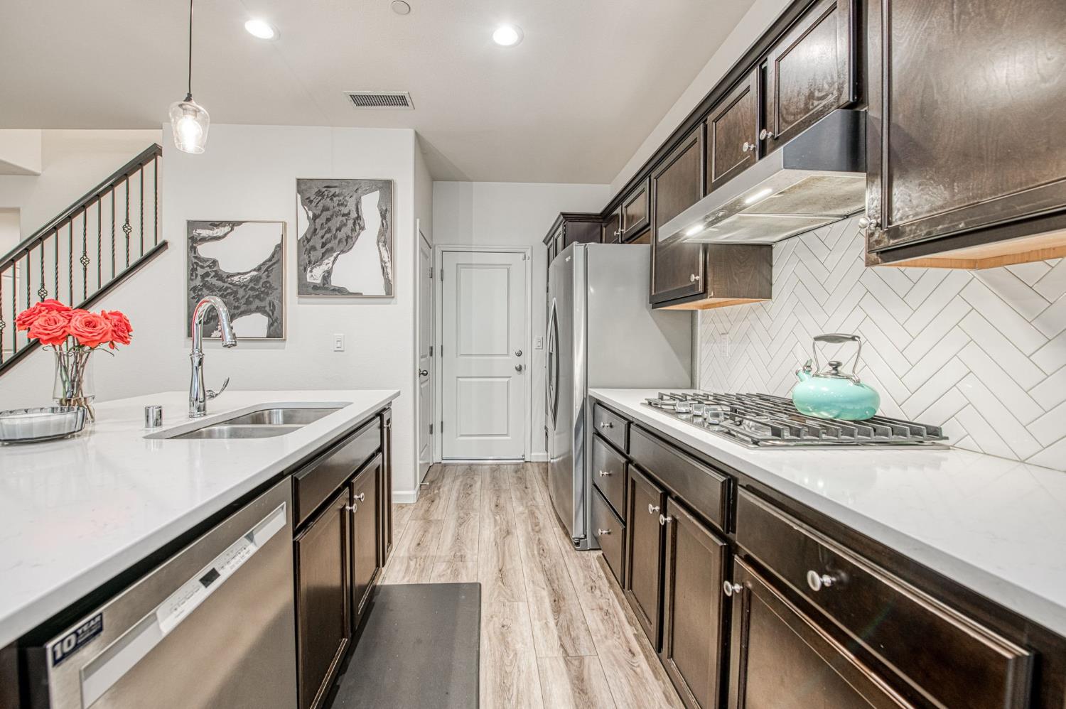 123 Capstone Way South Madera, CA 93636 - Photo 9 of 32 a kitchen with a sink stove and cabinets