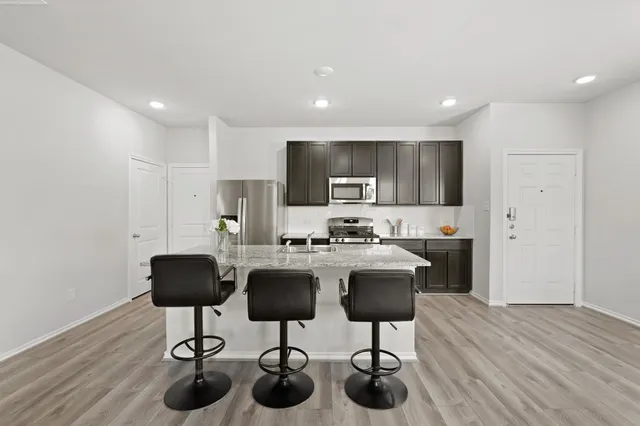 a kitchen with stainless steel appliances kitchen island granite countertop a sink and cabinets