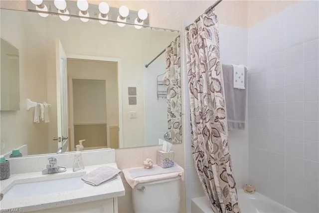 a bathroom with a sink a toilet and shower curtain
