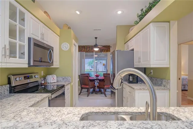 a kitchen with stainless steel appliances kitchen island granite countertop a sink and cabinets